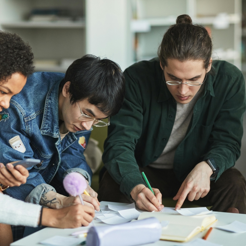 a group of people looking at papers
