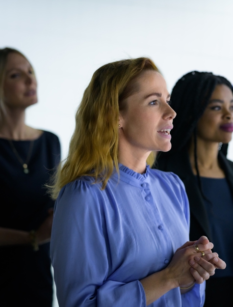 a group of women standing in front of a white board