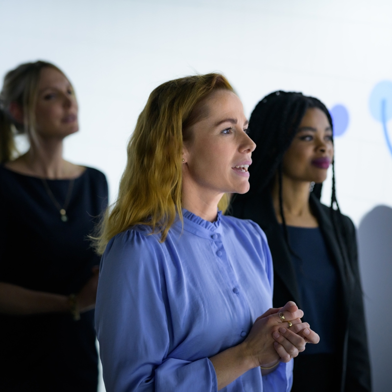 a group of women standing in front of a white board