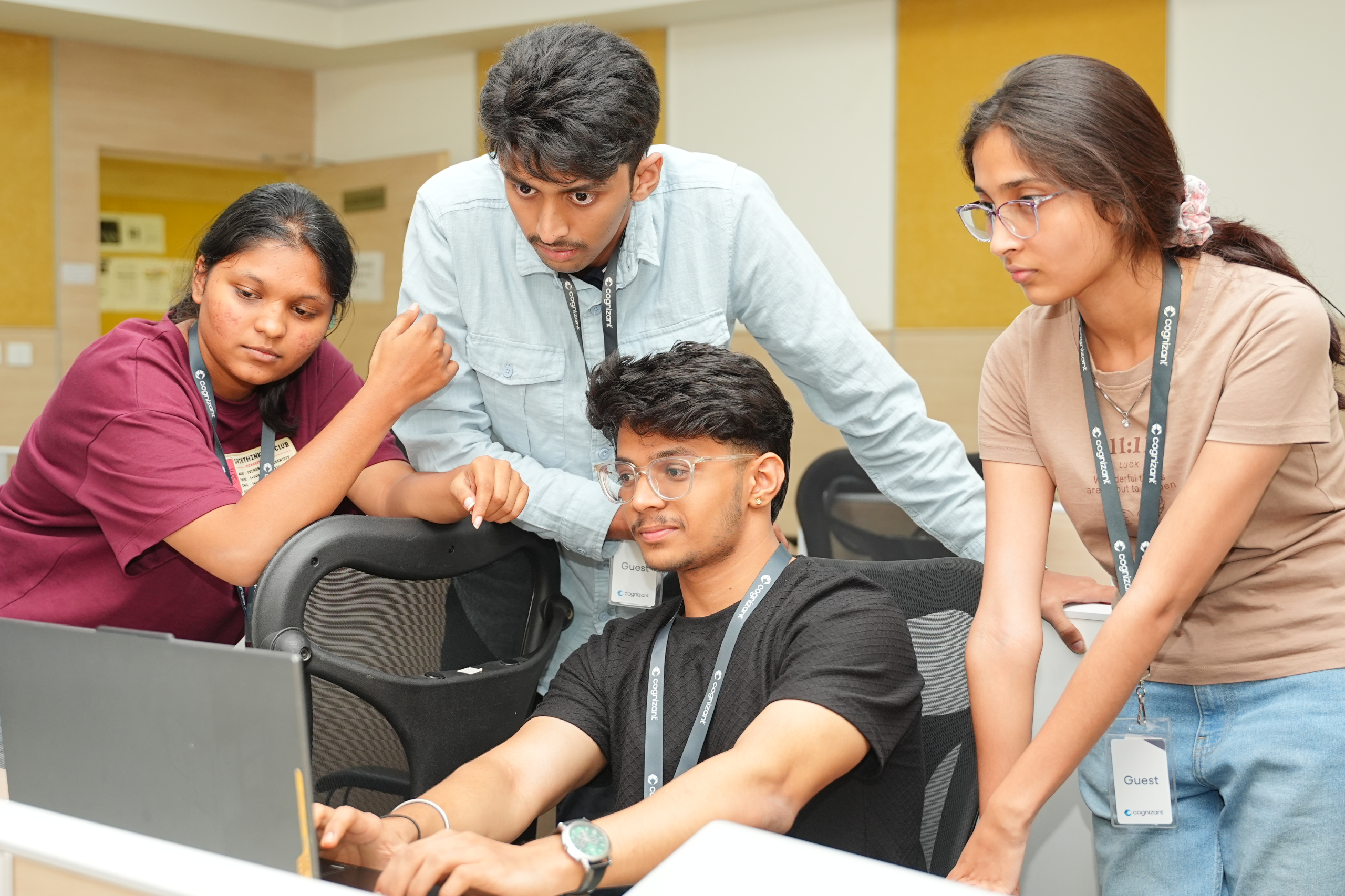 a group of people looking at a laptop