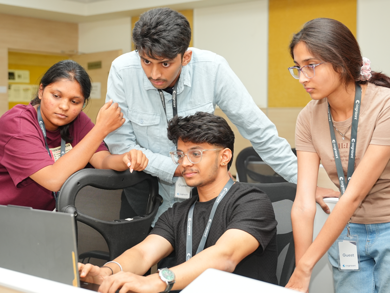a group of people looking at a laptop