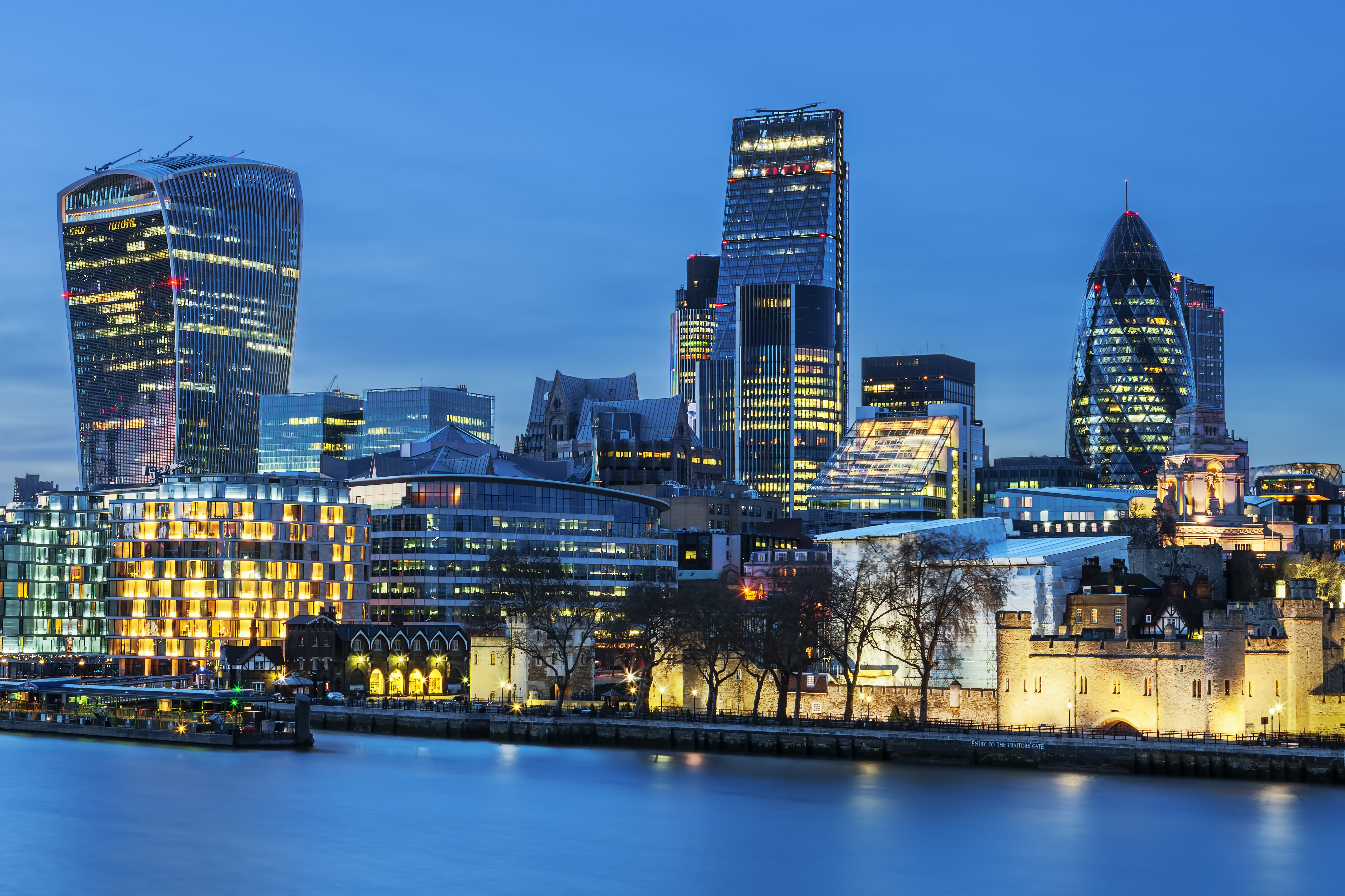 a city skyline with lights and a body of water