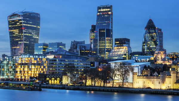 a city skyline with lights and a body of water