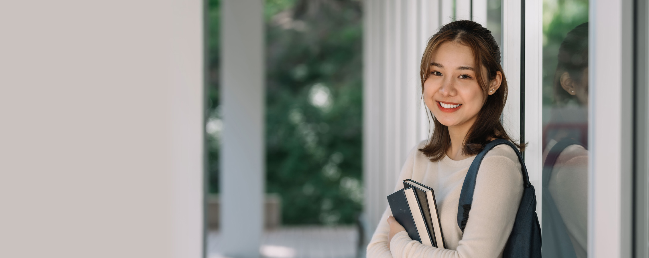 a person holding books and smiling