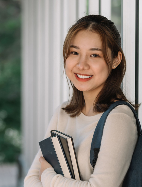 a person holding books and smiling