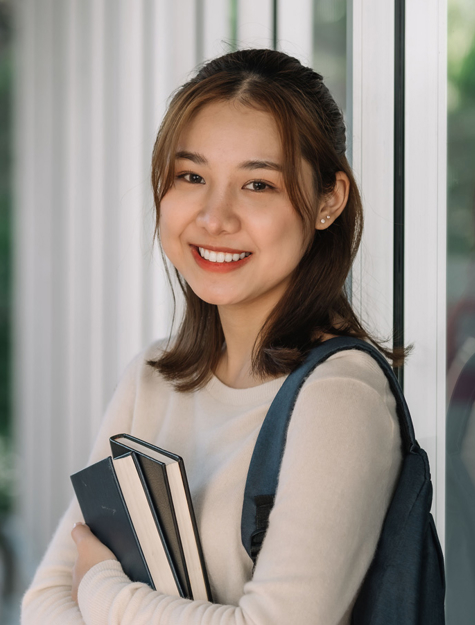 a person holding books and smiling