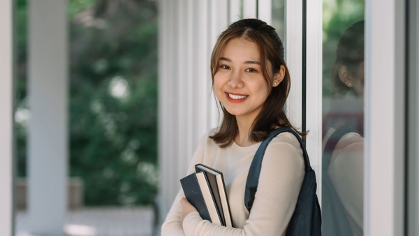 a person holding books and smiling