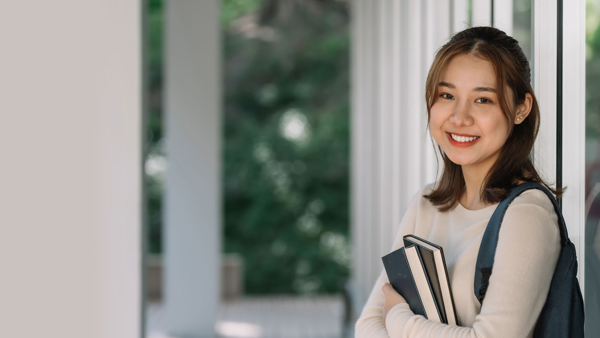 a person holding books and smiling