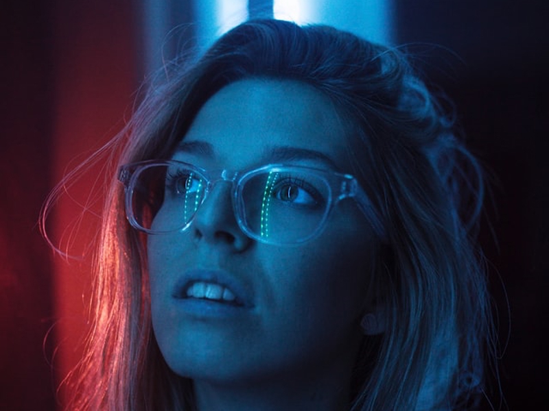 una mujer mirando hacia arriba con una luz azul y roja