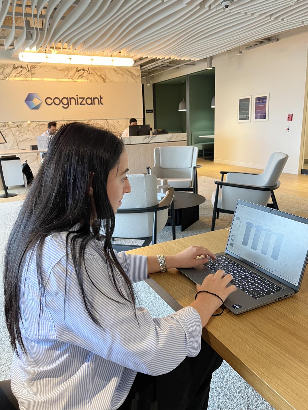 une personne assise à un bureau avec un portable
