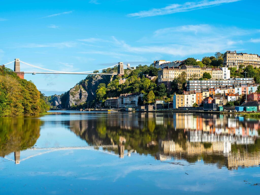 a bridge over a river with buildings and trees