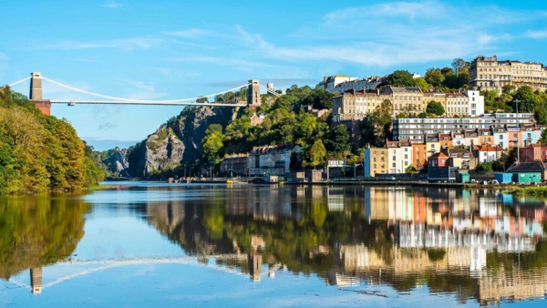 a bridge over a river with buildings and trees