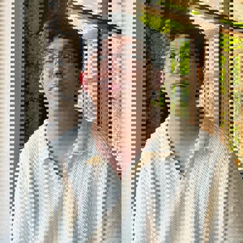 a person wearing glasses and a white shirt