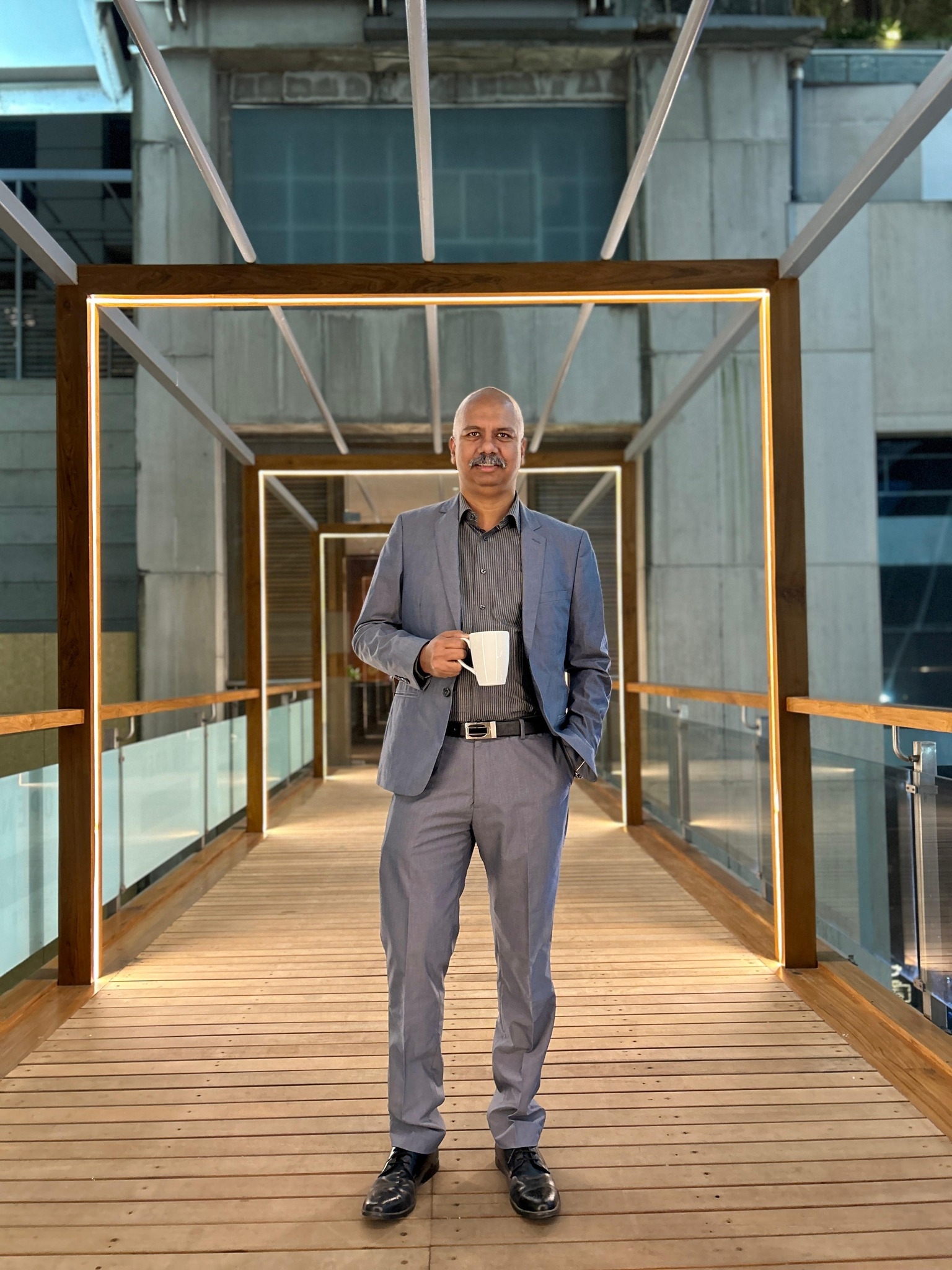 a person standing on a bridge holding a cup