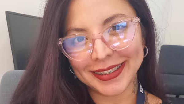 a person wearing glasses and a necklace