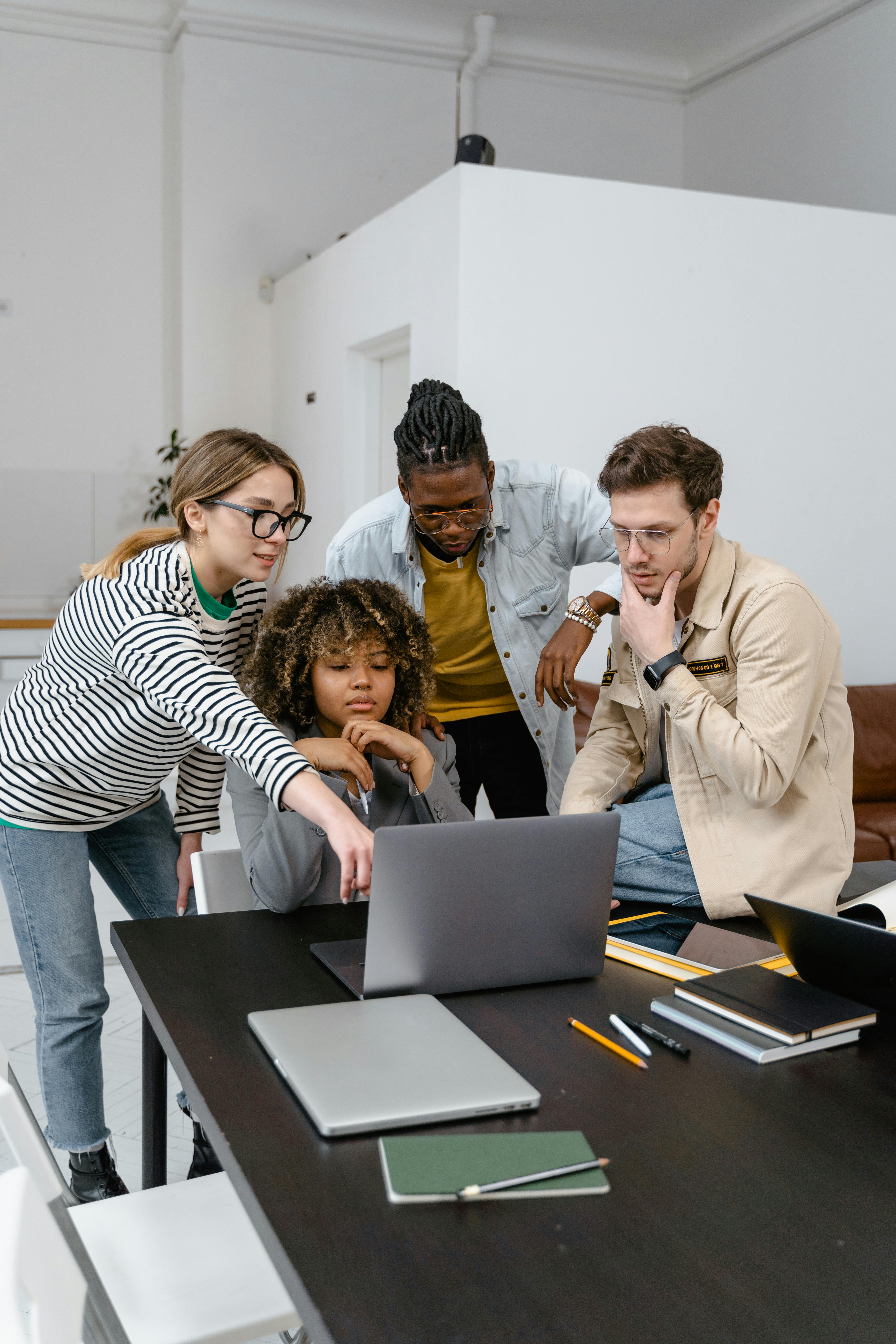 a group of people looking at a laptop