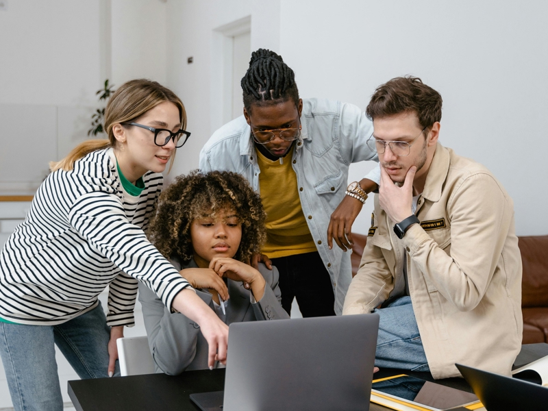 a group of people looking at a laptop