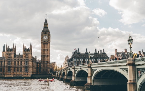 a bridge over water with a clock tower and a boat