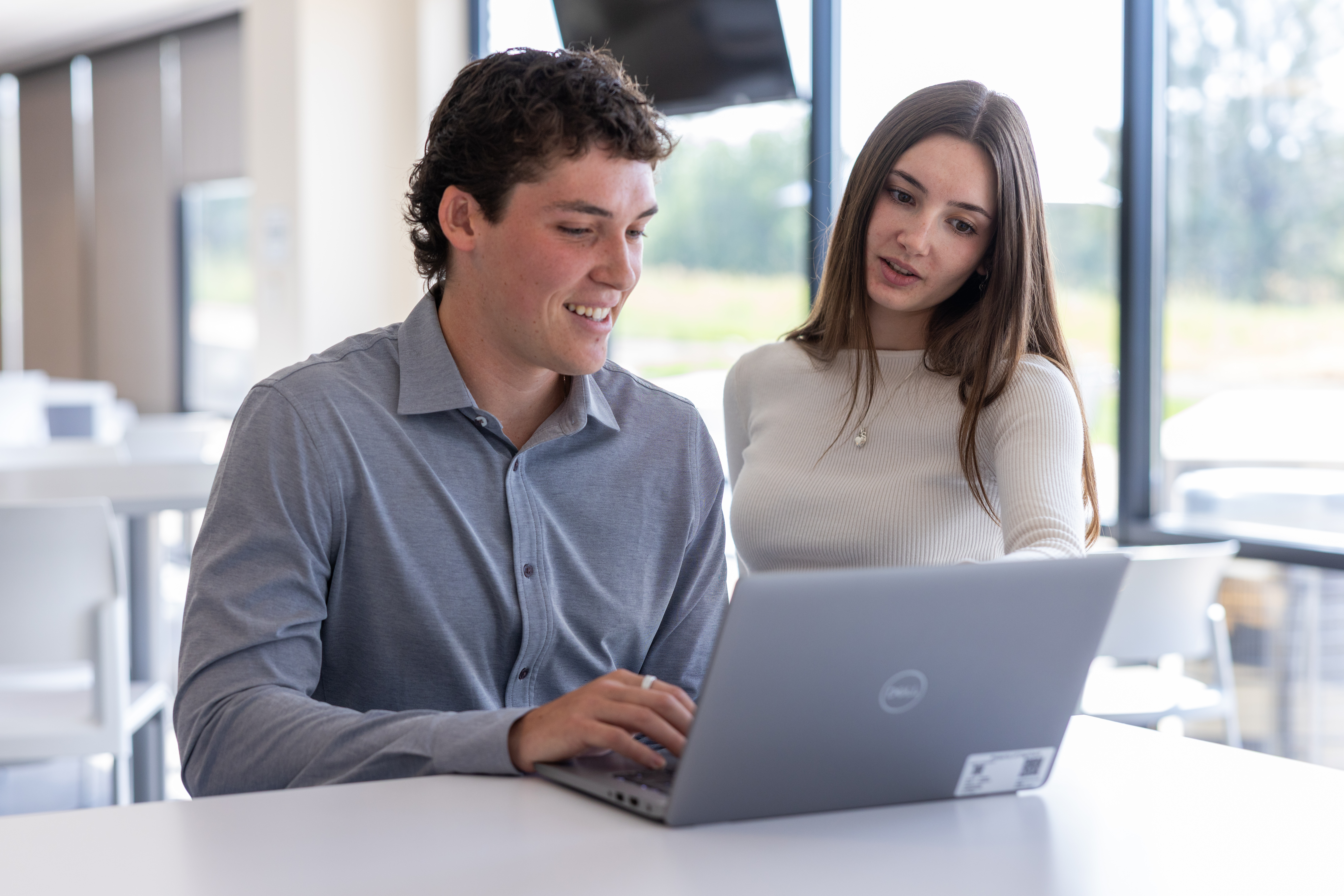 a person and person looking at a laptop