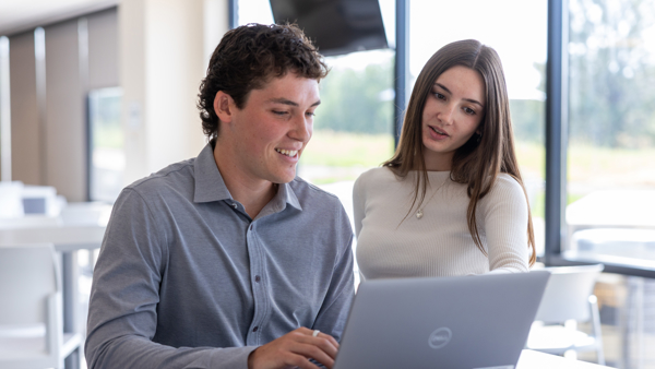 a person and person looking at a laptop