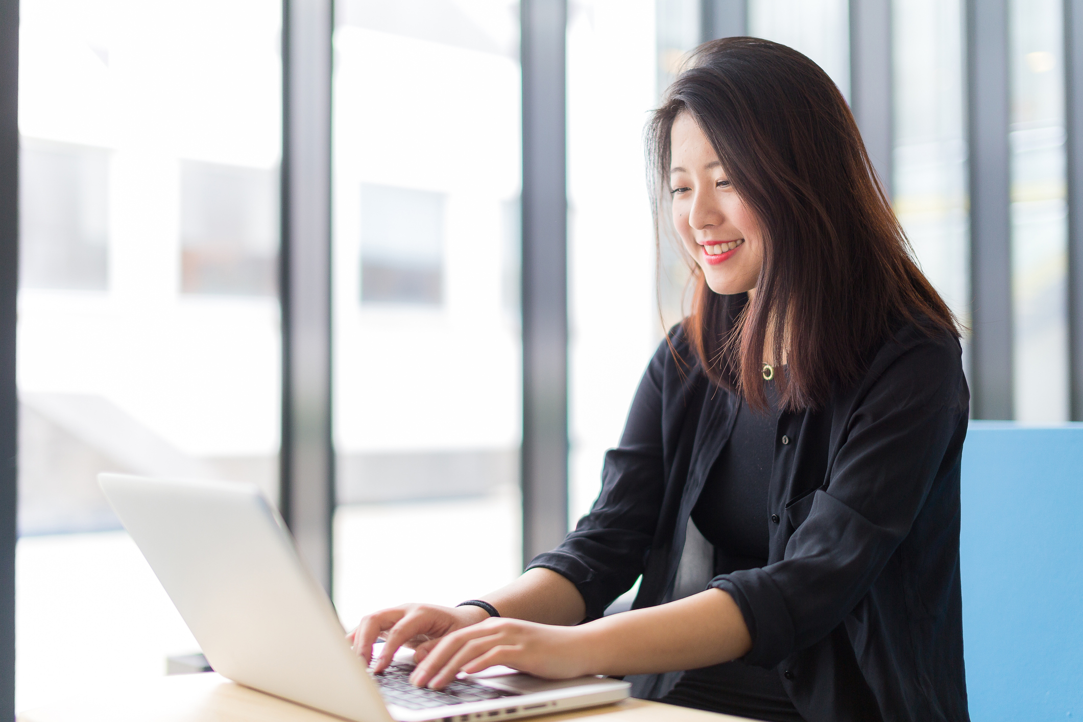 a person sitting at a desk typing on a laptop