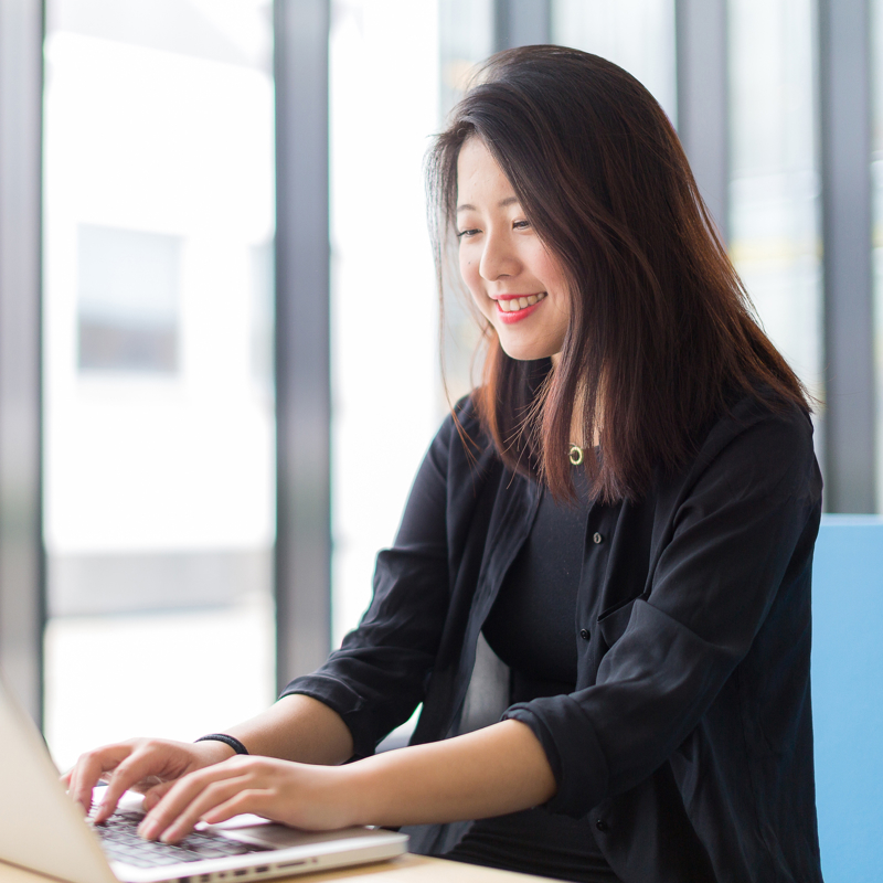 a person sitting at a desk typing on a laptop
