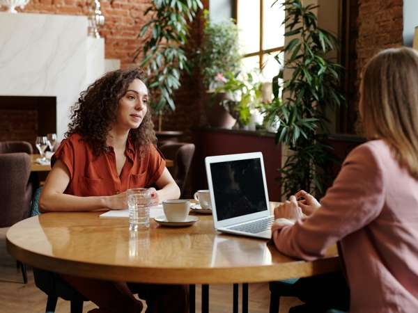 a person sitting at a table with a laptop