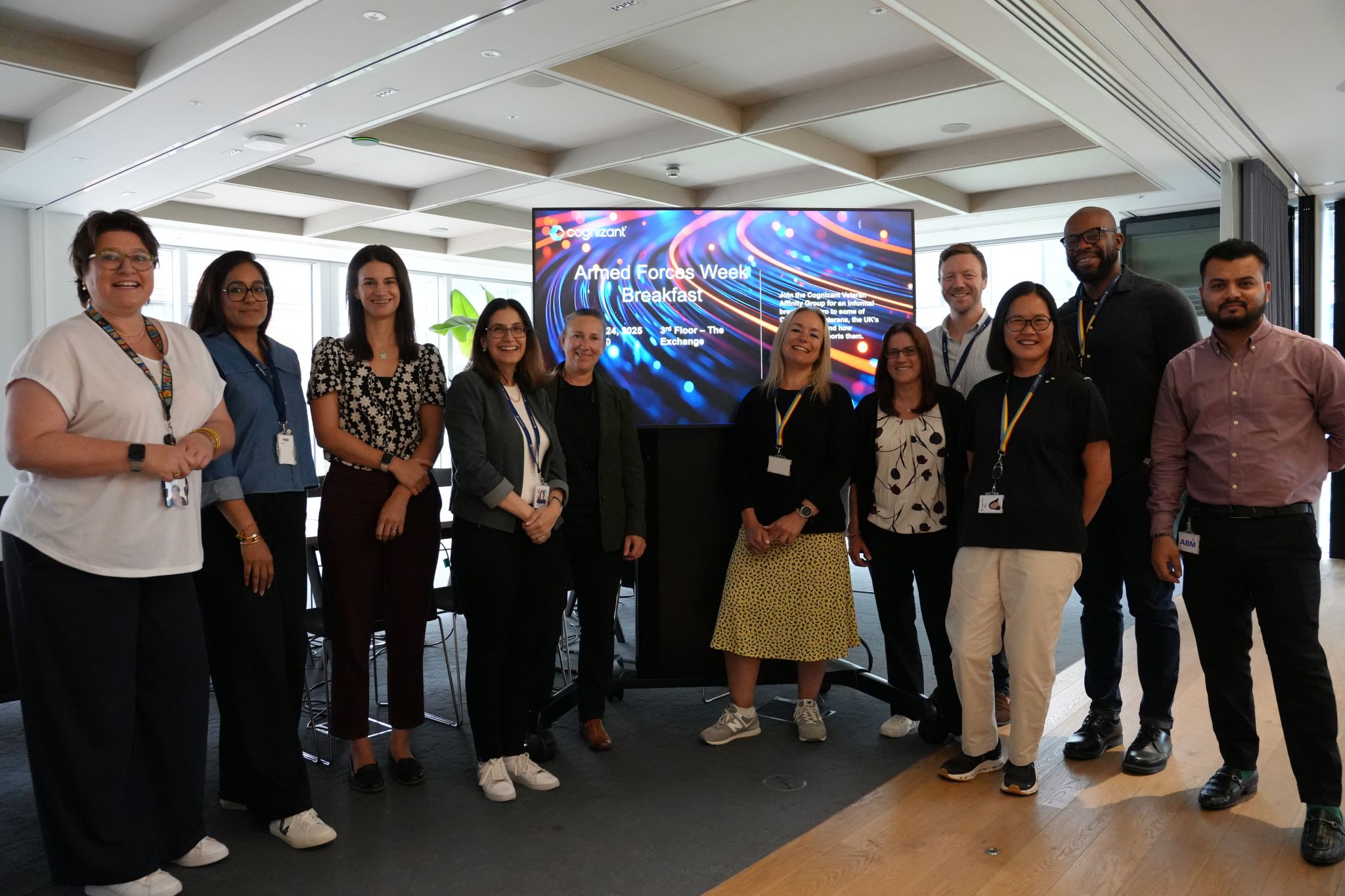 a group of people standing in front of a large screen