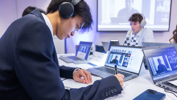 a person wearing headphones writing on a notebook