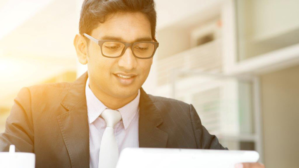 a person in a suit and tie looking at a tablet