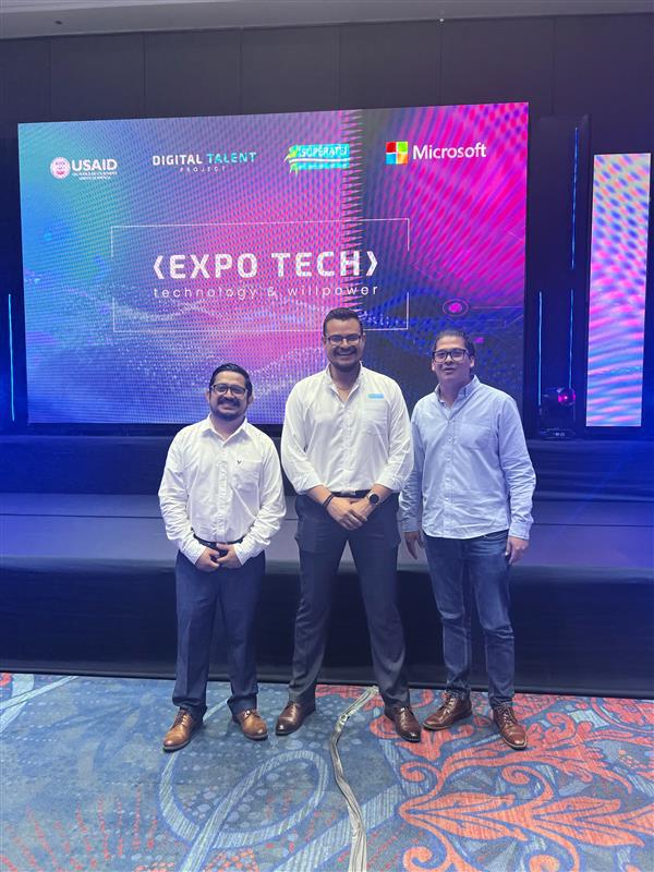 a group of men standing in front of a large screen