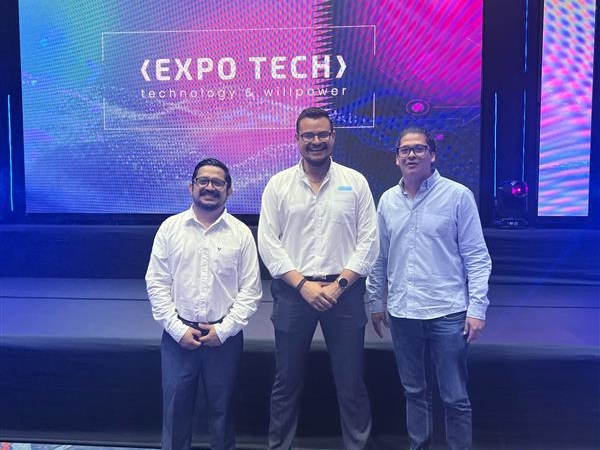 a group of men standing in front of a large screen