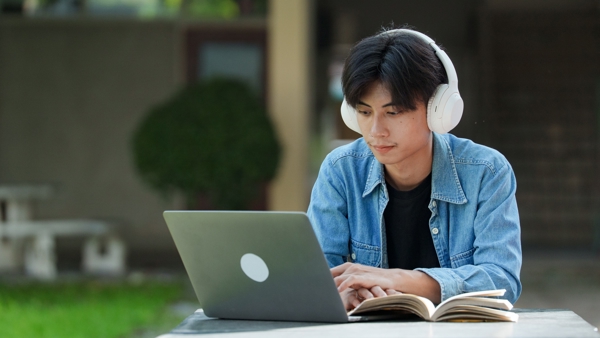 a person wearing headphones and using a laptop