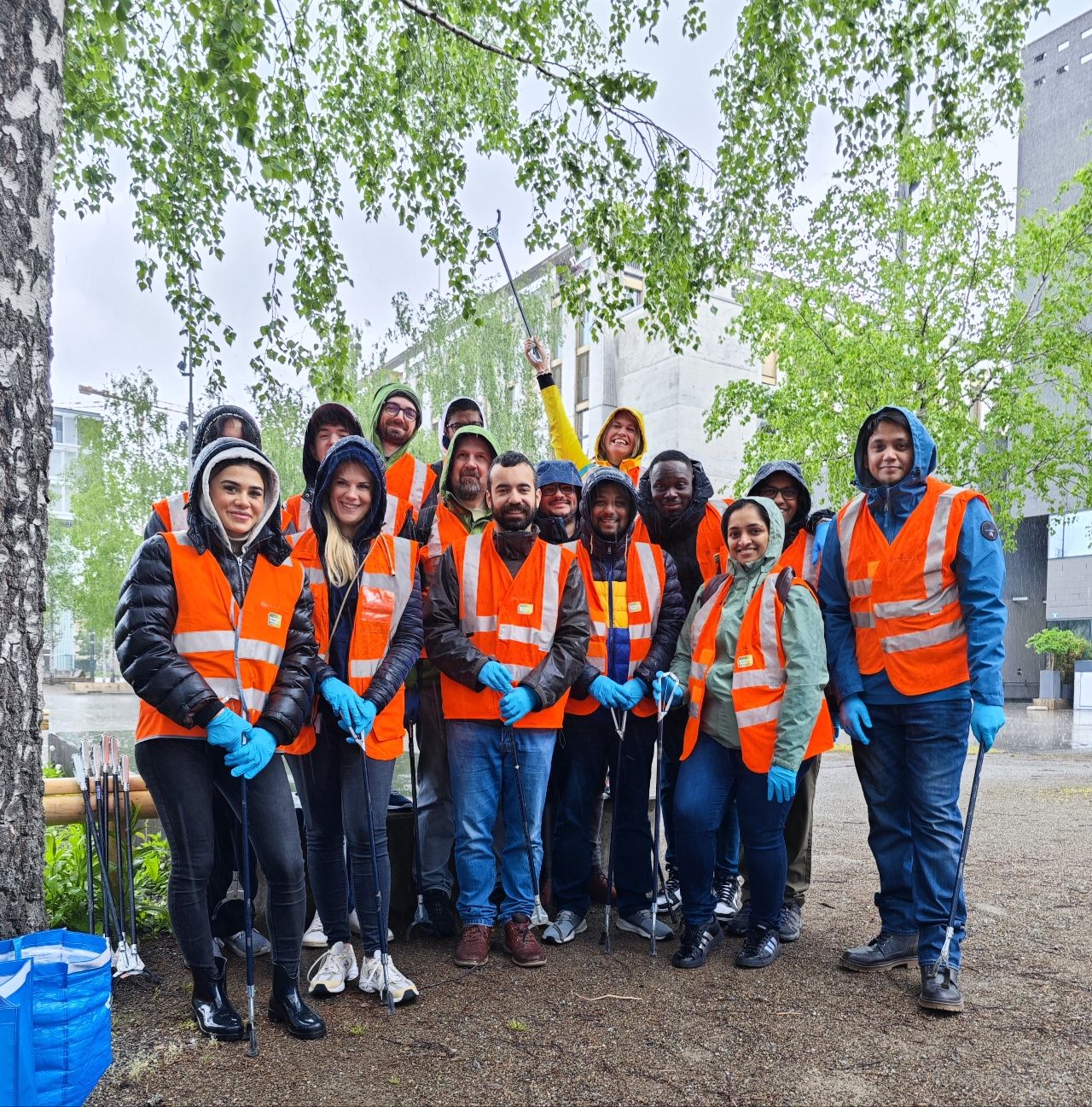 Een groep mensen in oranje vesten en kappen poseren voor een foto