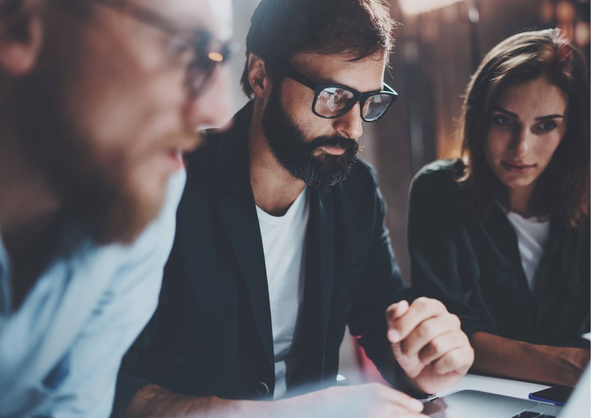 a group of people looking at a laptop