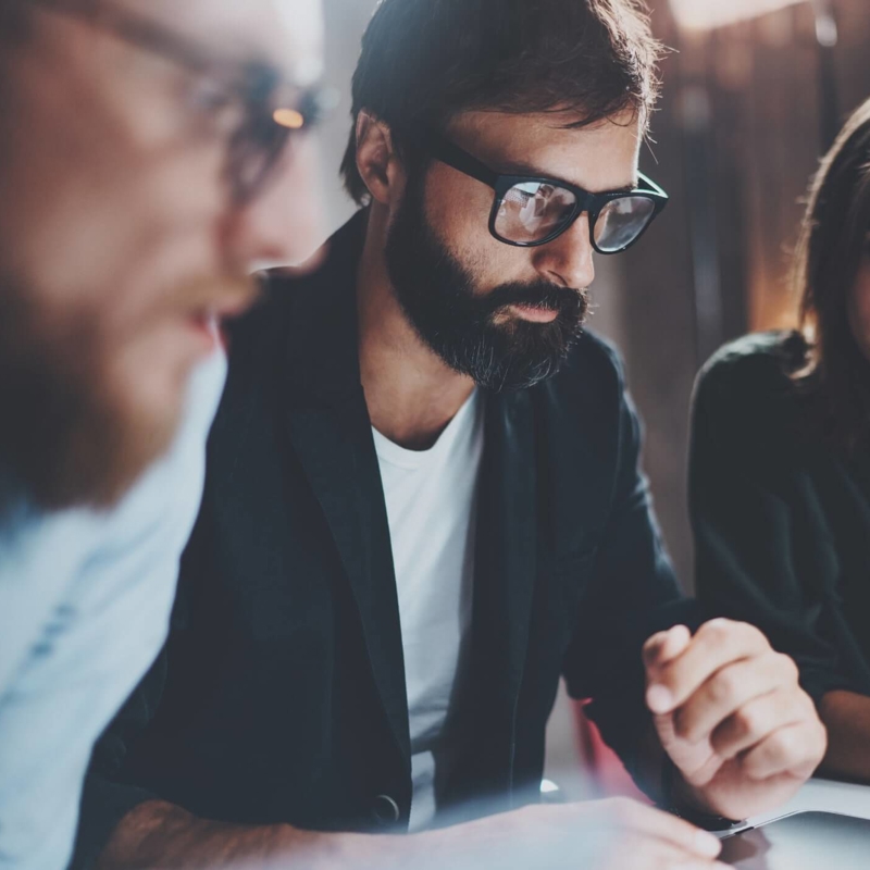 a group of people looking at a laptop