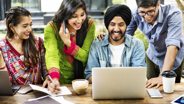 a group of people looking at a laptop