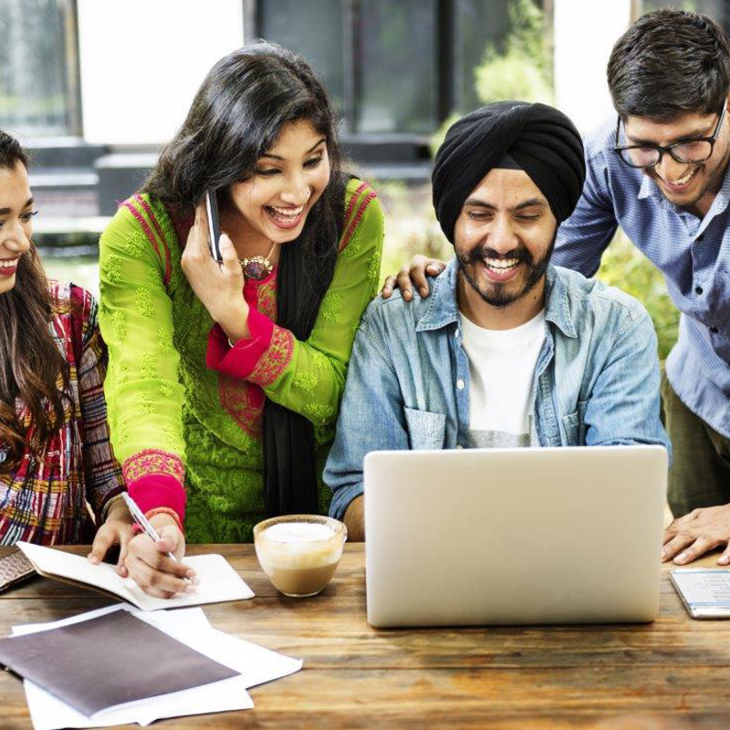 a group of people looking at a laptop