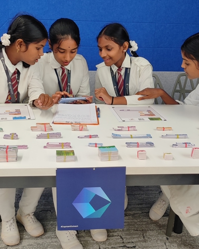 a group of childs sitting at a table with a table full of money