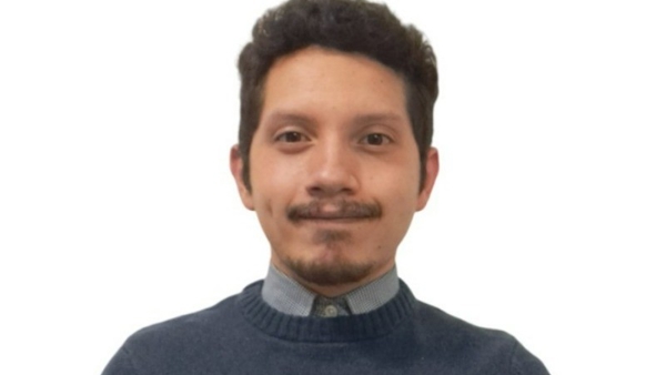 a person with a mustache and a blue sweater
