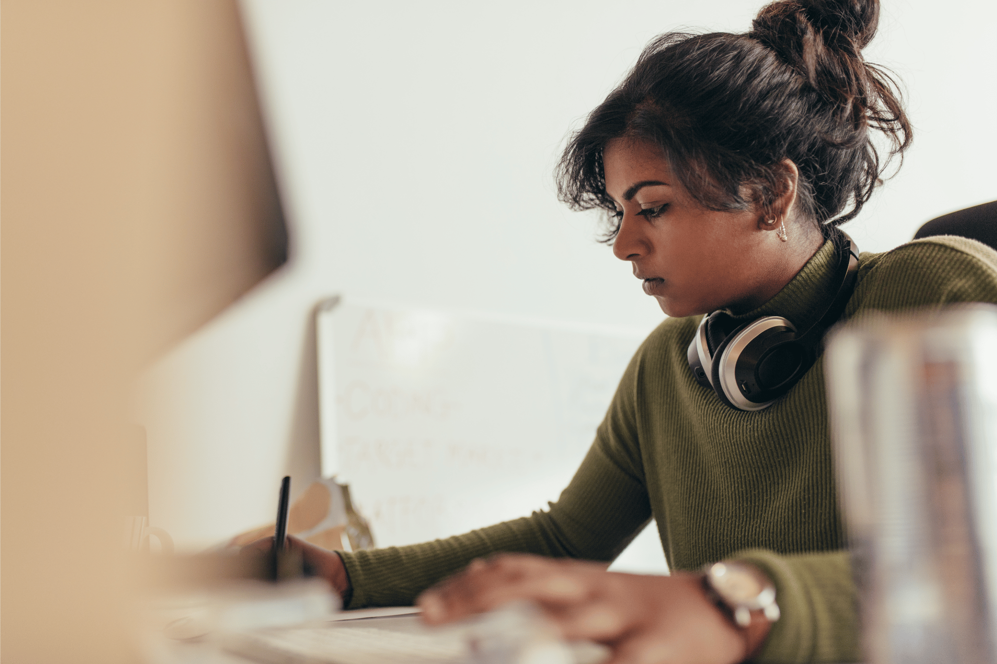 a person wearing headphones and writing on a paper