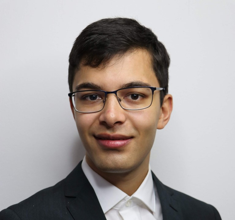 a person wearing glasses and a suit