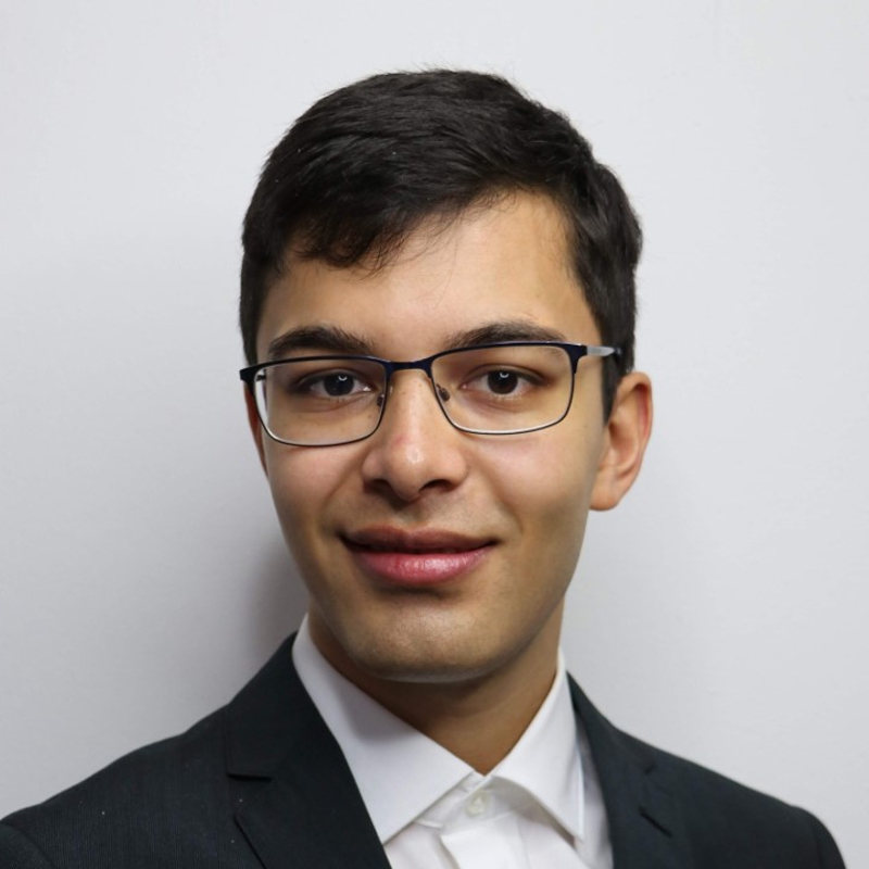 a person wearing glasses and a suit
