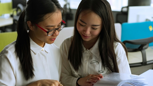 two women looking at a book