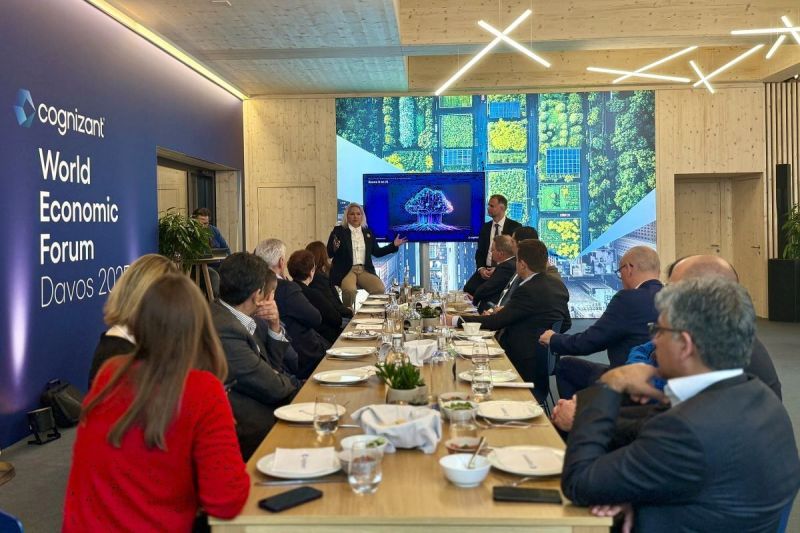 a group of people sitting at a long table