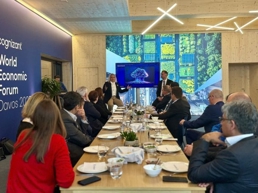 a group of people sitting at a long table