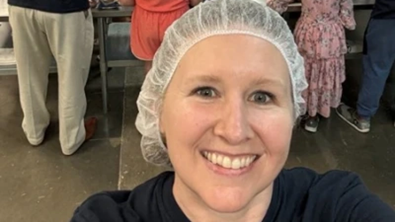a person taking a selfie in a room with persony people in hair nets