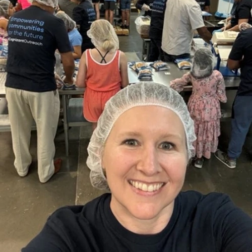 a person taking a selfie in a room with persony people in hair nets