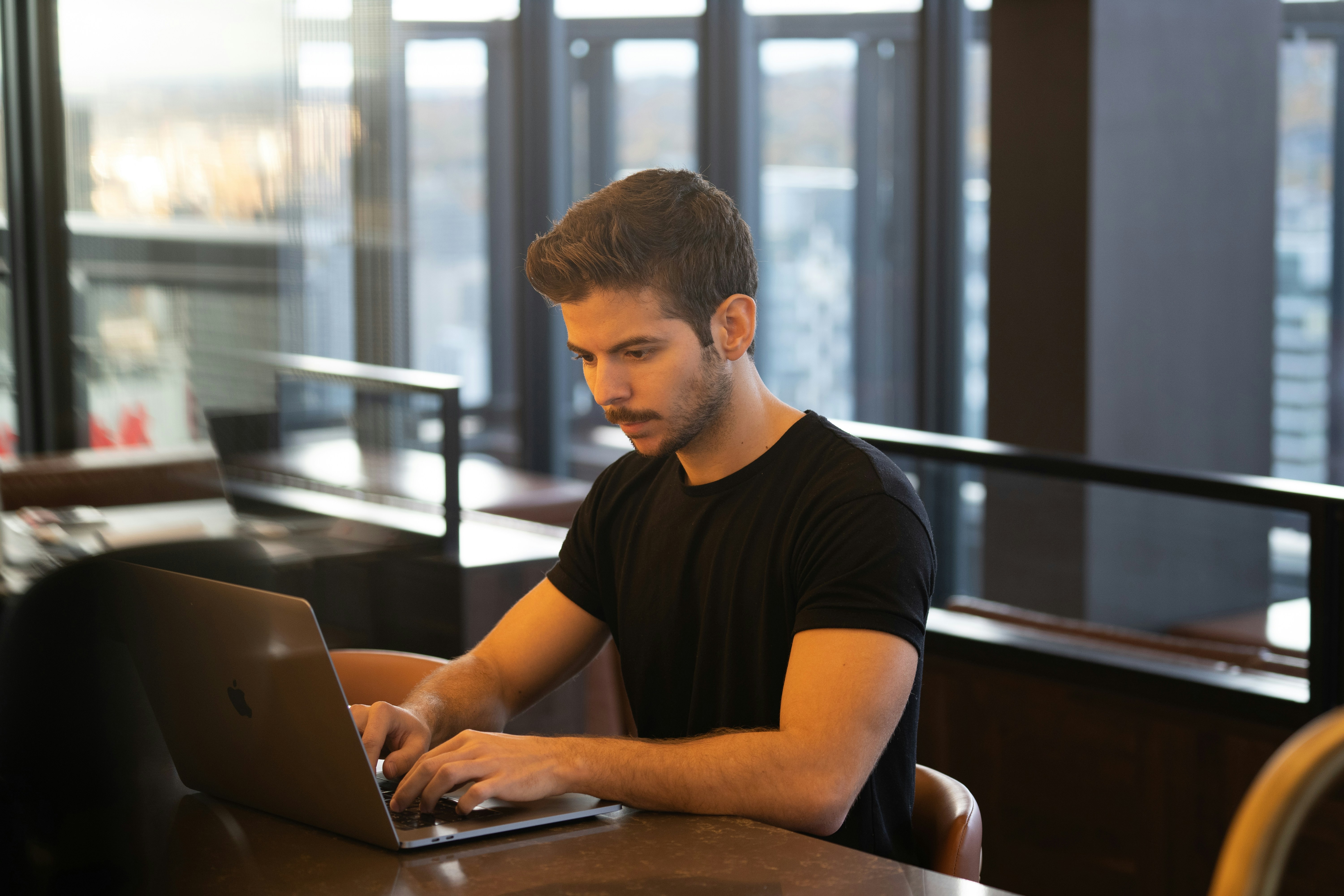 a person sitting at a table using a laptop