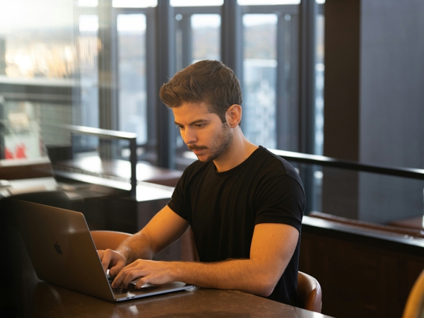 a person sitting at a table using a laptop